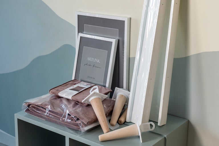 Dekorationselement som fotoramar, bordsben och textilier på ett bord