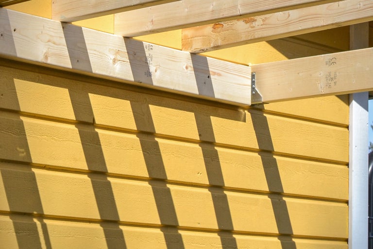 Detaljvy av en fasad med träpanel och träkonstruktion