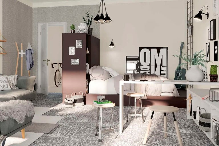 Ljust rum med säng, skrivbord och sittgrupp i modern design