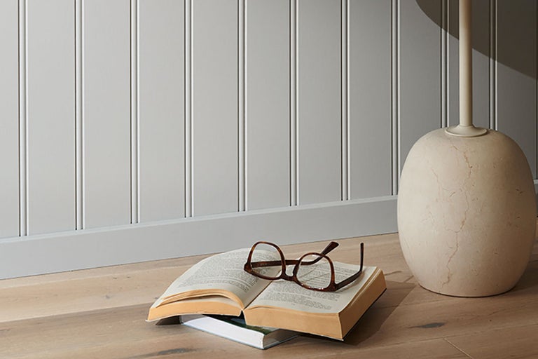 Väggpaneler med bok och glasögon på trägolvet