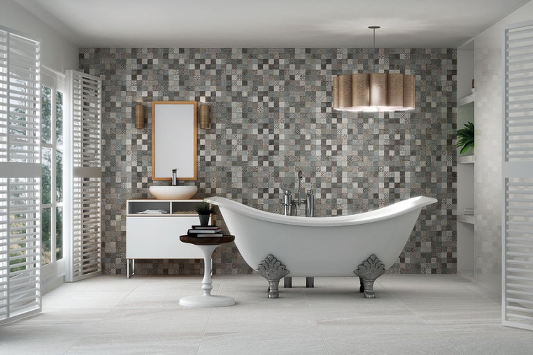 Badrum med fristående badkar, tvättställ, spegel, mosaikplattor och trädetaljer för en ljus och organiserad atmosfär.