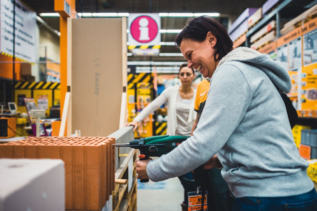 Kund borrar en tegelsten med en borrmaskin i Hornbach-butiken.