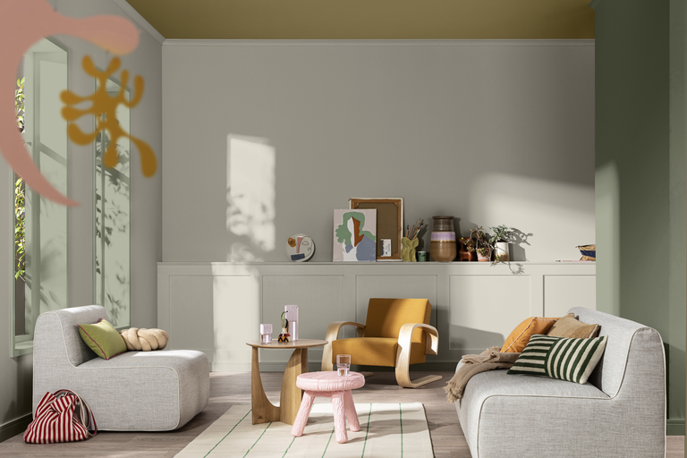 Vardagsrum med ljusgrå soffa, modern senapsgul fåtölj, träbord, rosa pall, väggpanel och abstrakta dekorationsföremål.