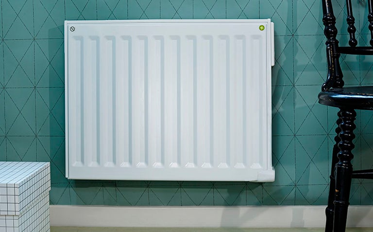 Vit panelradiator på en vägg