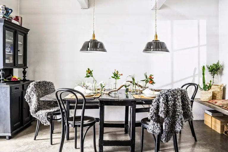 Matsal med matbord, stolar, pendellampor och skänk i lantlig stil