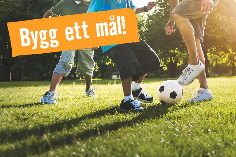 Scen av barn som spelar fotboll på en gräsmatta, med texten "Bygg ett mål!"