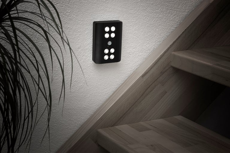 Svart LED-vägglampa med rörelsesdetektor bredvid en trappa