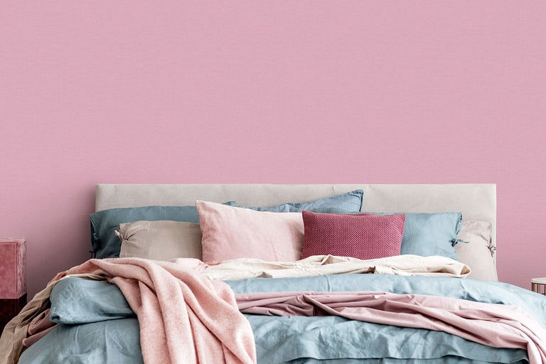 Ett sovrum med en säng framför en vägg med non-woven tapet.