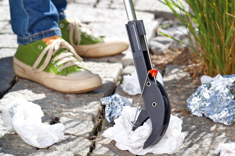 Person som plockar skräp med gripklo