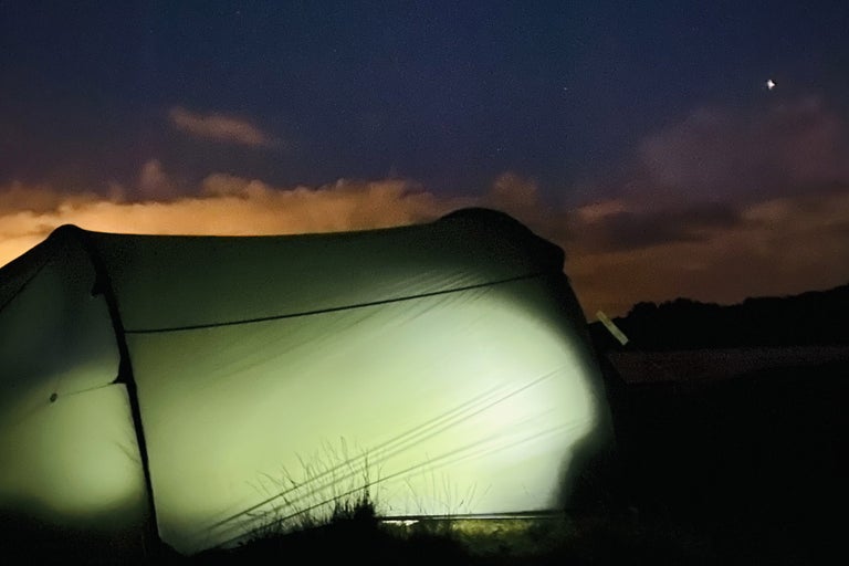 Upplyst tält i nattscen.