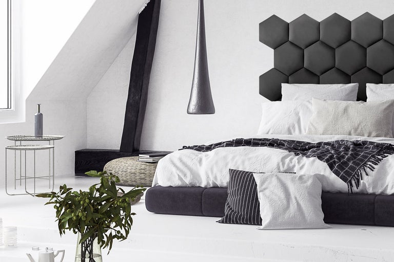 Sovrum med säng, nattduksbord och sexkantig väggdekoration