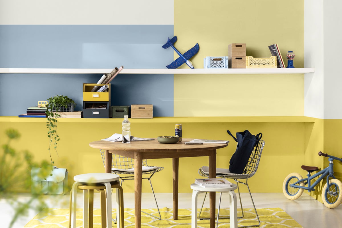 Ljust rum med träbord, stolar och hyllor med dekorativa föremål