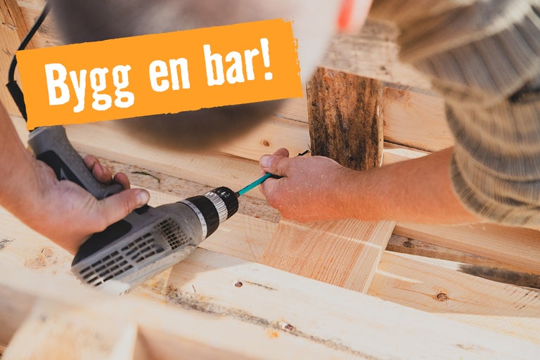 En person monterar trä för en bar med en sladdlös skruvdragare.
