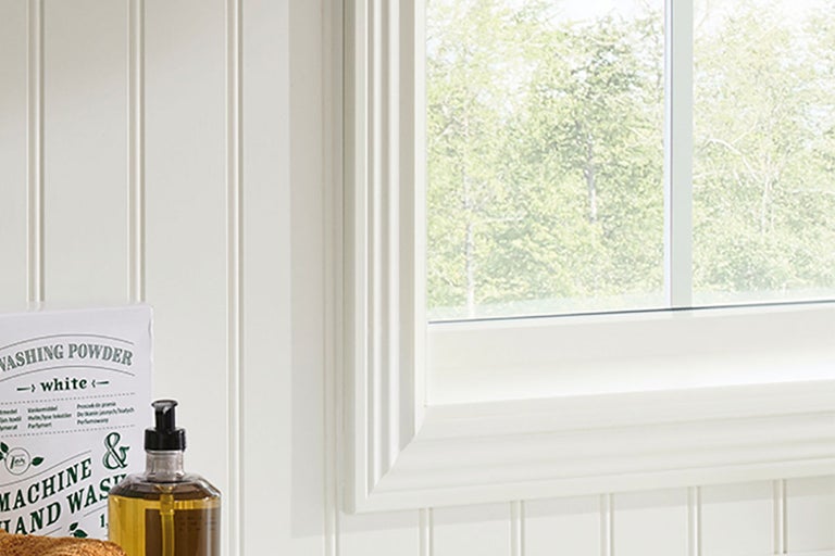 Detaljvy av ett vitt fönster med spröjsram