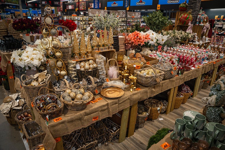 Visning av dekorativa föremål på bord i en Hornbach-butik.