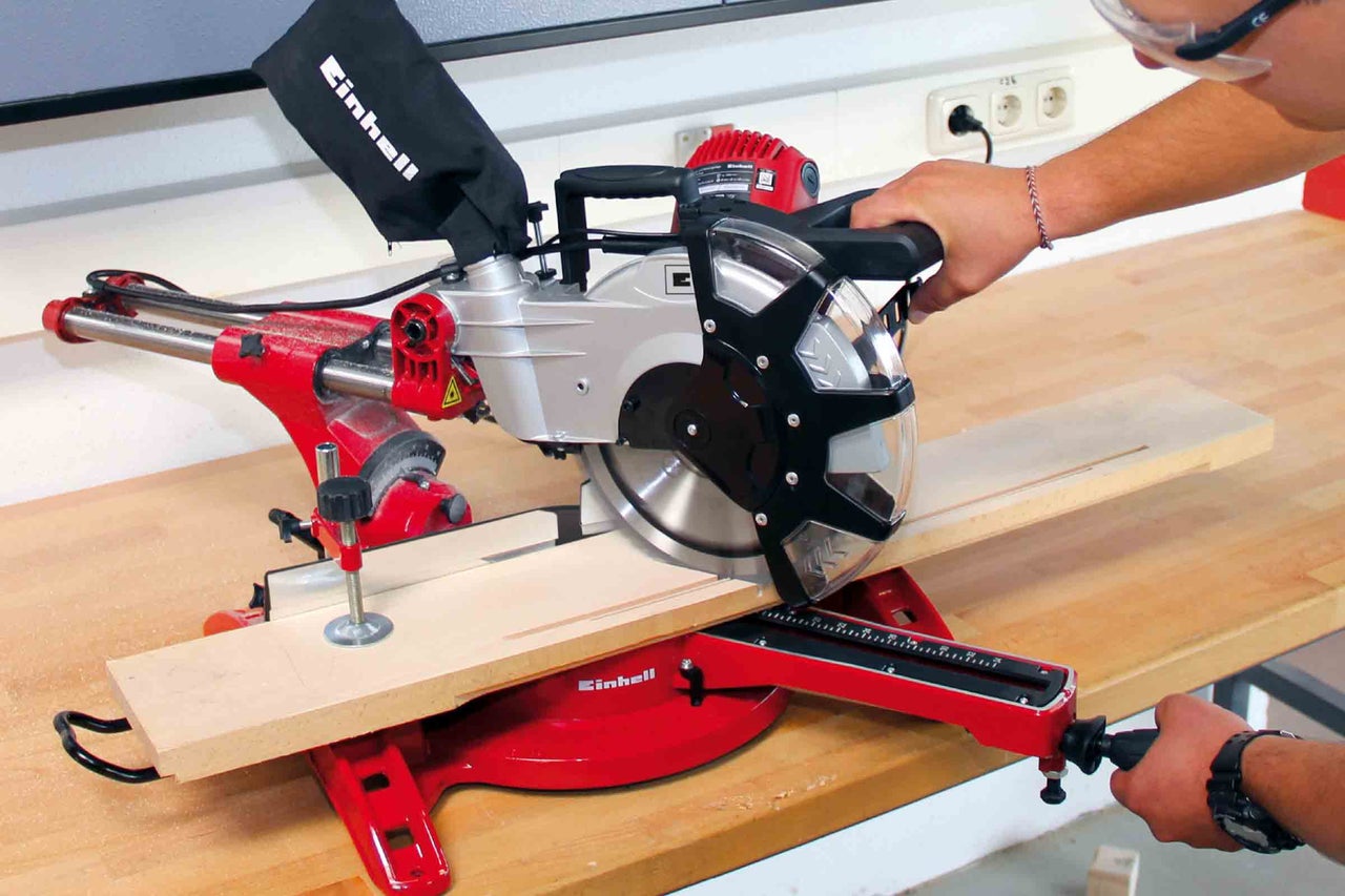 Einhell kap- och geringssåg som sågar en bit trä