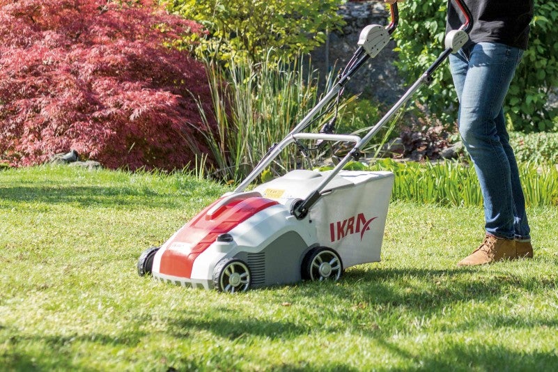 Trädgårdslandskap med gräsmattluftare i bruk