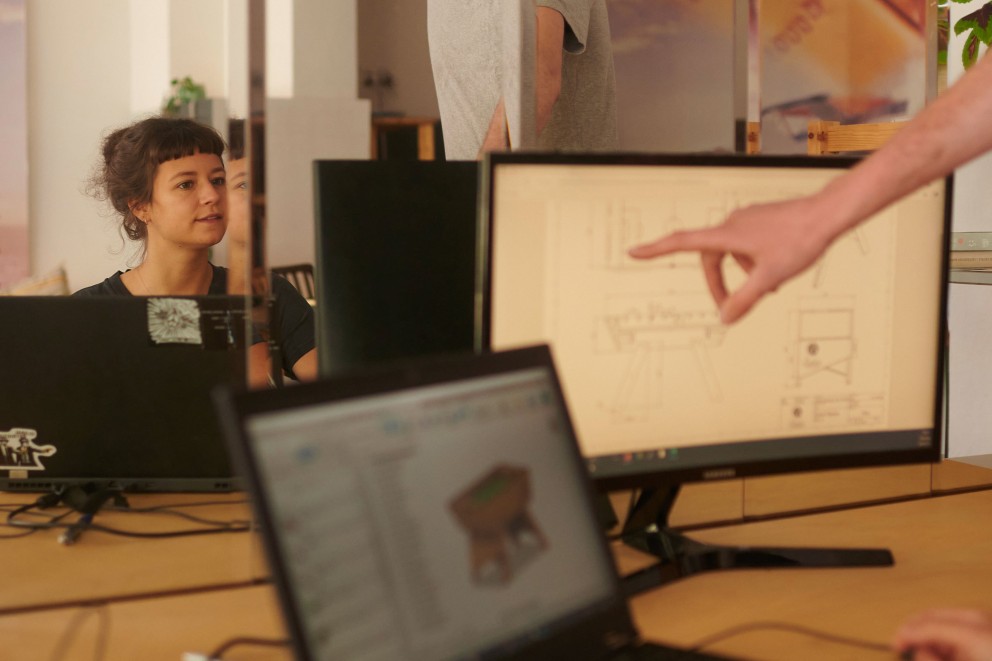 André visar Lili ritningen på datorn. Data från den tekniska ritningen matas in i CNC fräsmaskinen. André visar Lili ritningen på datorn. Data från den tekniska ritningen matas in i CNC fräsmaskinen.