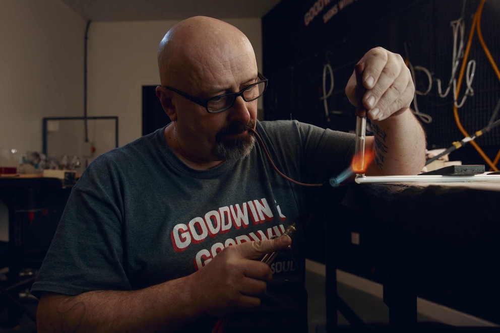 
				Precisionsarbete med eld: Paul förseglar glasröret innan det kan fyllas med ädelgas.

			
