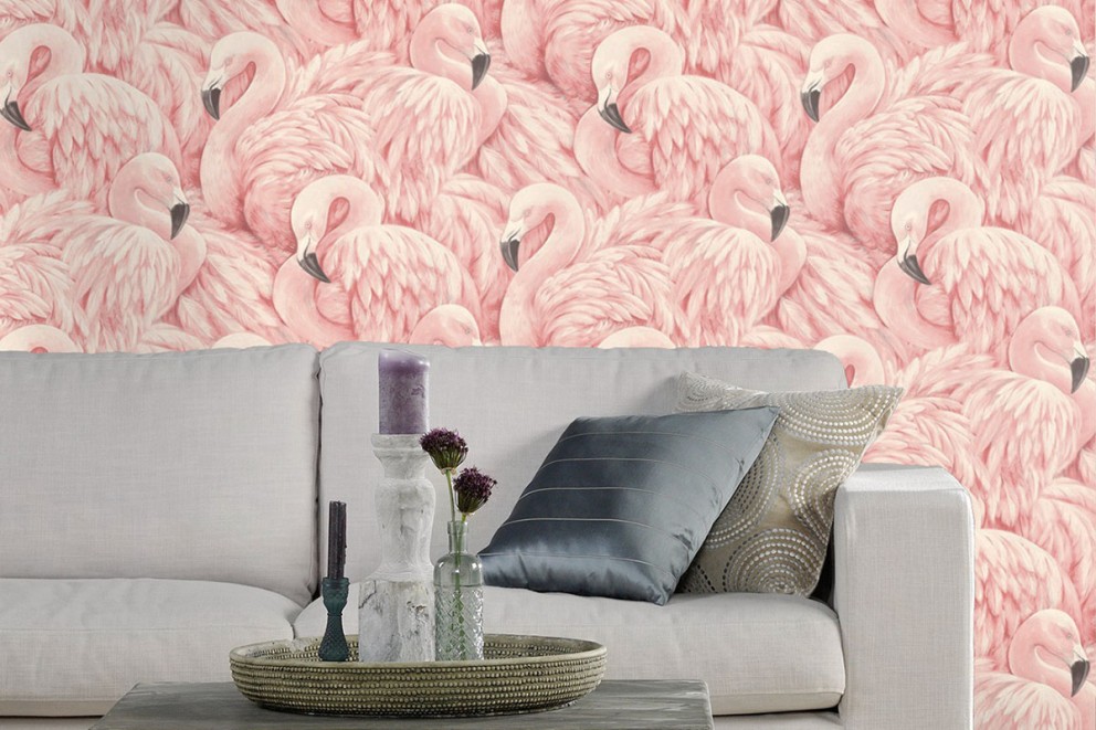 Vardagsrum med soffa framför en tapet med flamingor