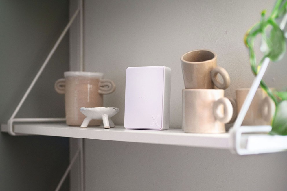 Scen med en wifi-repeater på en hylla tillsammans med muggar och dekoration