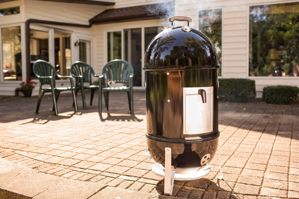 Klotgrill på en terrass med trädgårdsmöbler