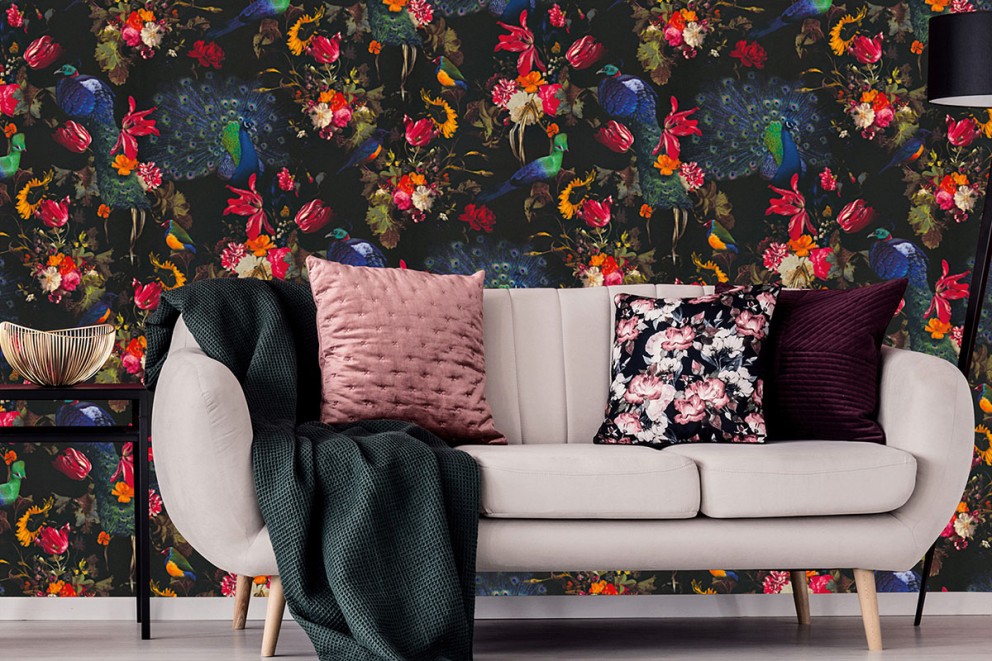 Rumsdekoration med soffa, kuddar och tapet med iögonfallande mönster med blom- och fågelmotiv