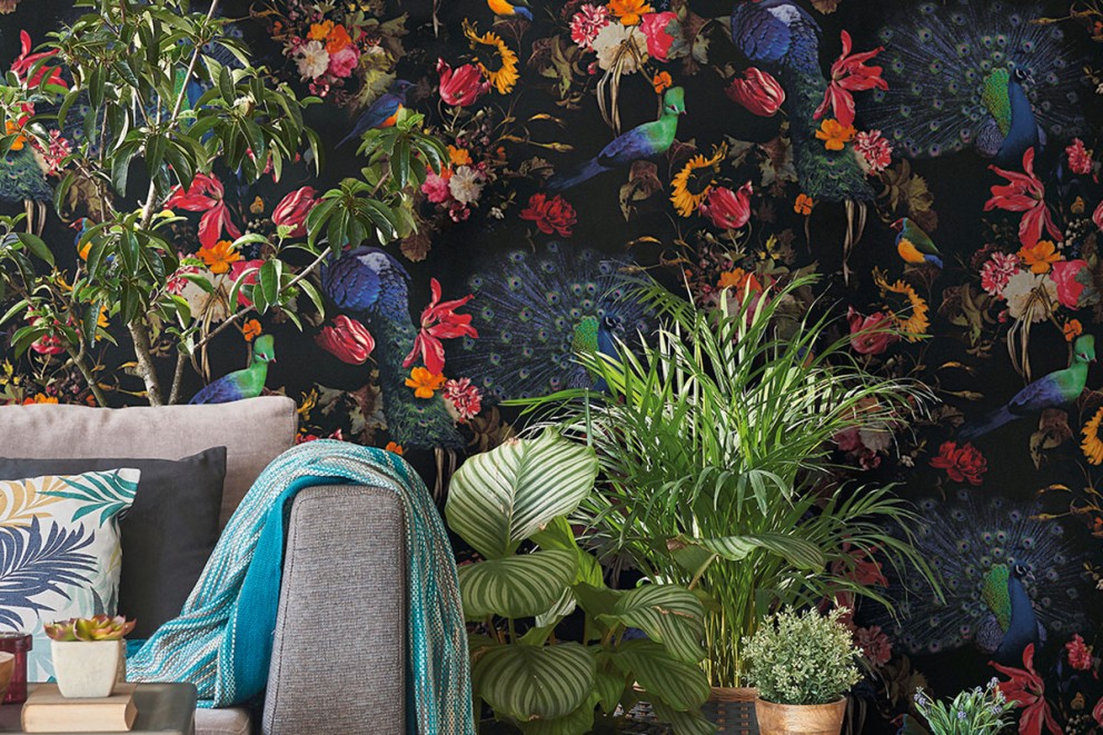 Vardagsrum med soffa och blommig tapet med fågelmotiv