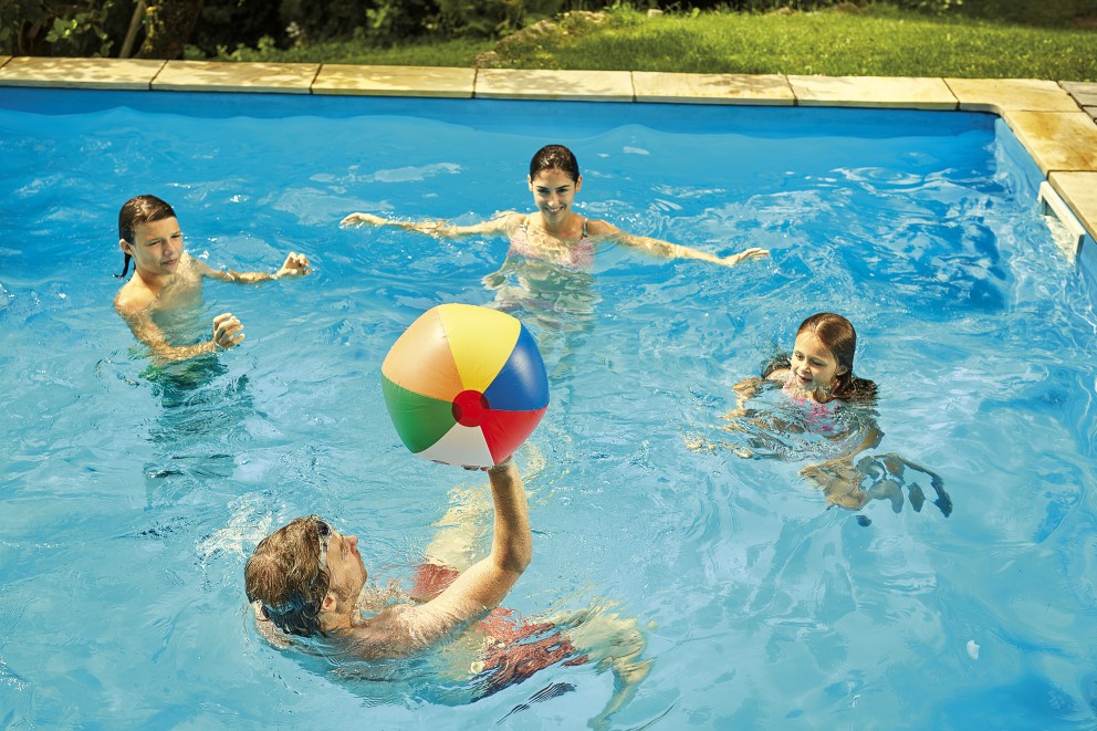 Poolscen med fyra personer och en färgglad badboll