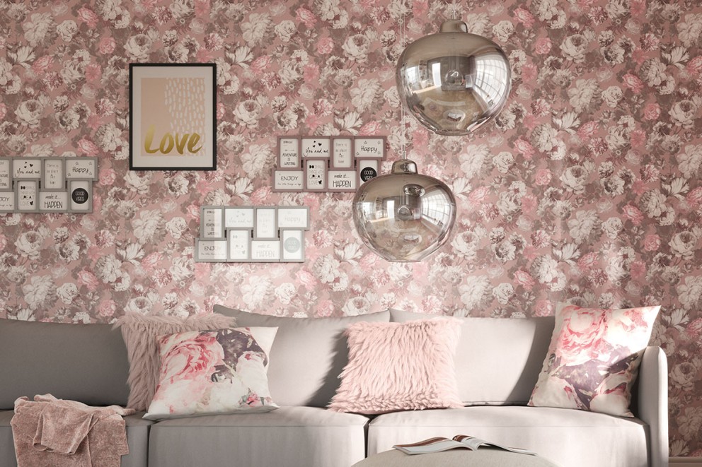 Vardagsrum med soffa, kuddar, två hänglampor och en vägg med blommig tapet, affischer och fotoramar