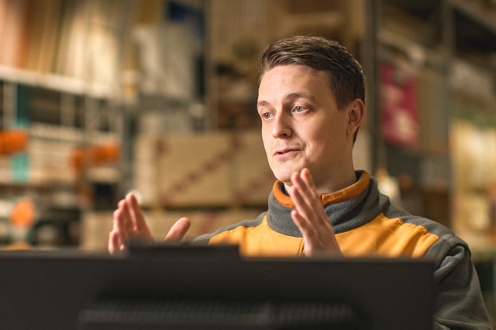 En man gestikulerar framför en hylla i ett Hornbach-varuhus