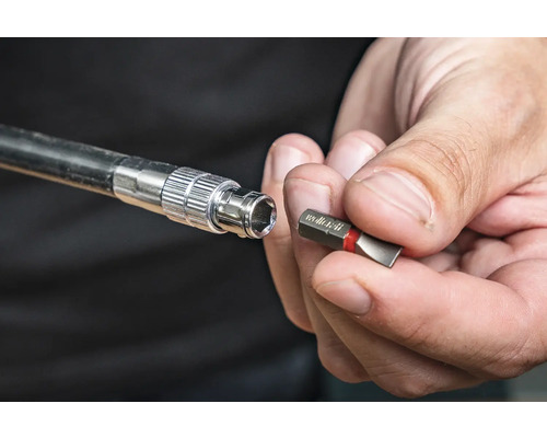 Hylsnyckel med bits hålls av en hand