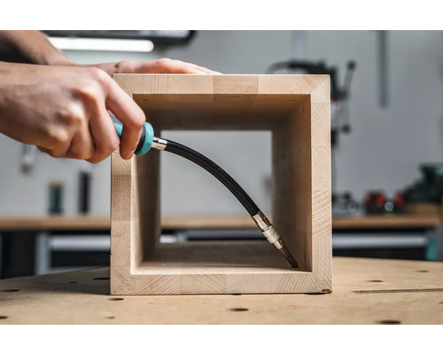 En person arbetar med en flexibel skruvmejsel på ett trästycke.