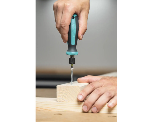En person skruvar in en skruv i en träbit med en skruvmejsel.