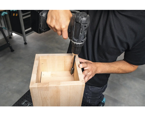 Hantverkare skruvar ihop en trämöbel med en sladdlös borrmaskin