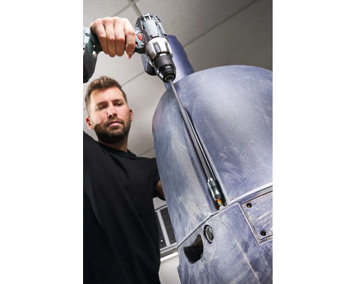 En man skruvar fast en plastkomponent med en sladdlös skruvdragare.