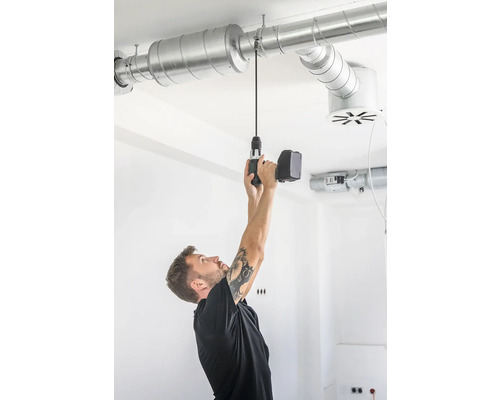Man monterar ventilationsrör i taket med en sladdlös skruvdragare.