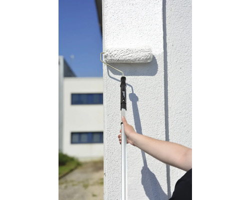 Måla en vägg med en färgroller med teleskopskaft