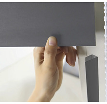 En person fäster en persienn.