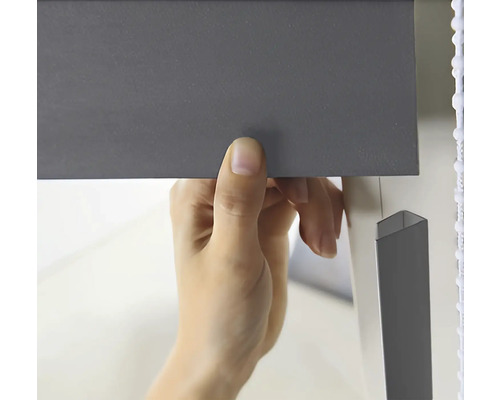 En person fäster en persienn.