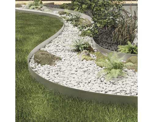 Trädgårdslandskap med gräsmatta, grusgång och metallkant