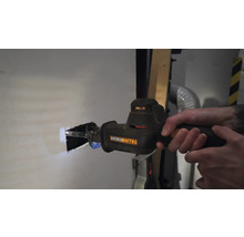 En person sågar ett hål i en vägg med en tigersåg. Verktyg från Worx Nitro.