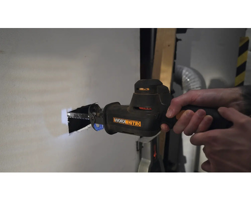 En person sågar ett hål i en vägg med en tigersåg. Verktyg från Worx Nitro.