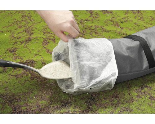 Skovel fyller sandsäck med sand