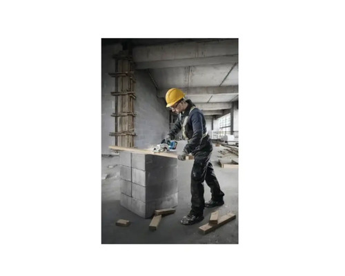 En hantverkare med skyddshjälm sågar en träplanka med en cirkelsåg.