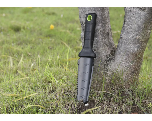 Trädgårdsredskap med handtag och mätskala lutad mot ett träd