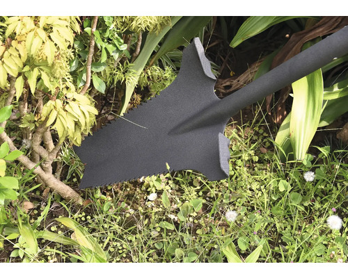 Trädgårdsspade med sågtänder i trädgården.