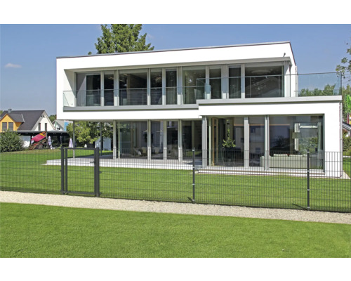 Modernt hus med dubbeltrådsstängsel som tomtgräns