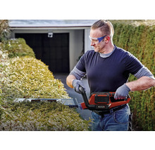 Man klipper häck med en elektrisk häcksax från Einhell.
