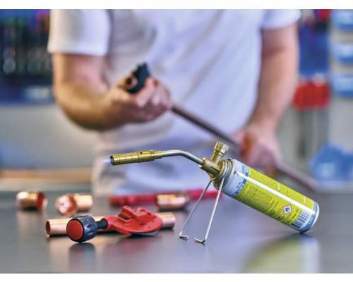 Lödlampa med kopparrör och rörskärare på en arbetsbänk